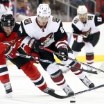 Arizona Coyotes left wing Mikkel Boedker, right, of Denmark, skates against New Jersey Devils left wing Jiri Tlusty, of the Czech Republic, during the first period of an NHL hockey game, Tuesday, Oct. 20, 2015, in Newark, N.J. (AP Photo/Julio Cortez)