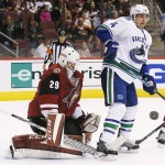 Vancouver Canucks' Alex Burrows (14) tries to find the puck as is goes wide of Arizona Coyotes' Anders Lindback (29), of Sweden, during the first period of an NHL hockey game Friday, Oct. 30, 2015, in Glendale, Ariz. (AP Photo/Ross D. Franklin)