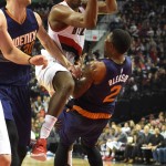 Portland Trail Blazers forward Al-Farouq Aminu (8) charges into Phoenix Suns guard Eric Bledsoe (2) during the third quarter of  an NBA basketball game in Portland, Ore., Saturday, Oct. 31, 2015. The Suns won the game 101-90. (AP Photo/Steve Dykes)