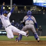 Kansas City Royals' Alcides Escobar, left, scores past New York Mets catcher Travis d'Arnaud on a single by Eric Hosmer during the fifth inning of Game 2 of the Major League Baseball World Series Wednesday, Oct. 28, 2015, in Kansas City, Mo. (AP Photo/Matt Slocum)