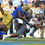 Arizona State wide receiver Tim White, second from right, scores a touchdown under pressure from UCLA defensive back Tahaan Goodman, left, and defensive lineman Sam Tai, second from right, while wide receiver Gary Chambers blocks for White during the first half of an NCAA college football game, Saturday, Oct. 3, 2015, in Pasadena, Calif.  (AP Photo/Mark J. Terrill)