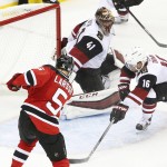 New Jersey Devils defenseman Adam Larsson (5), of Sweden, scores a goal against Arizona Coyotes goalie Mike Smith (41) and center Max Domi (16) during overtime of an NHL hockey game, Tuesday, Oct. 20, 2015, in Newark, N.J. The Devils won 3-2 in overtime. (AP Photo/Julio Cortez)