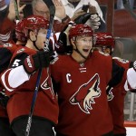 Arizona Coyotes' Shane Doan, right, celebrates his goal with teammates, including Nicklas Grossmann (2), of Sweden, and Connor Murphy (5), during the first period of an NHL hockey game against the Boston Bruins Saturday, Oct. 17, 2015, in Glendale, Ariz.  For Doan it was his 900th NHL point. (AP Photo/Ross D. Franklin)