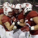 Stanford's Christian McCaffrey, left, is mobbed by teammates after his touchdown run against Arizona during the first half of an NCAA college football game Saturday, Oct. 3, 2015, in Stanford, Calif.  (AP Photo/Marcio Jose Sanchez)