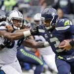 Seattle Seahawks quarterback Russell Wilson, right, tries to fend off Carolina Panthers outside linebacker Shaq Thompson, left, in the second half of an NFL football game, Sunday, Oct. 18, 2015, in Seattle. The Panthers defeated the Seahawks 27-23. (AP Photo/Elaine Thompson)