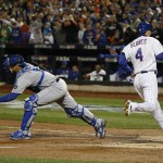 Kansas City Royals catcher Salvador Perez waits for the throw as New York Mets' Wilmer Flores (4) scores on a sacrifice fly during the third inning of Game 4 of the Major League Baseball World Series Saturday, Oct. 31, 2015, in New York. (AP Photo/Matt Slocum)
