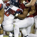 Stanford's Solomon Thomas, right, loses his helmet as he tackles Arizona's Nick Wilson during the first half of an NCAA college football game Saturday, Oct. 3, 2015, in Stanford, Calif.  (AP Photo/Marcio Jose Sanchez)
