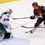 Minnesota Wild's Devan Dubnyk (40) makes a save on a shot by Arizona Coyotes' Steve Downie (17) as Wild's Jonas Brodin (25), of Sweden, defends during the second period of an NHL hockey game Thursday, Oct. 15, 2015, in Glendale, Ariz. (AP Photo/Ross D. Franklin)