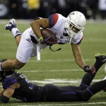 Arizona safety Johnny Jackson is tripped up by Washington's Brian Clay on a carry in the first half an NCAA college football game Saturday, Oct. 31, 2015, in Seattle. (AP Photo/Elaine Thompson)