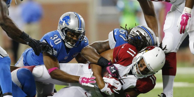 Arizona Cardinals wide receiver Larry Fitzgerald (11) is tackled by Detroit Lions defensive back Jo...