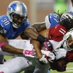 Arizona Cardinals wide receiver Larry Fitzgerald (11) is tackled by Detroit Lions defensive back Josh Wilson (30) and outside linebacker Josh Bynes (57) during the second half of an NFL football game, Sunday, Oct. 11, 2015, in Detroit. (AP Photo/Rick Osentoski)