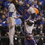 New York Mets pitcher Jacob deGrom, left, speaks to catcher Travis d'Arnaud during the fifth inning of Game 2 of the Major League Baseball World Series Wednesday, Oct. 28, 2015, in Kansas City, Mo. (AP Photo/Matt Slocum)