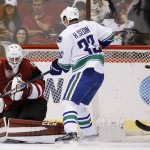 Arizona Coyotes' Anders Lindback, left, of Sweden, gives up a goal to Vancouver Canucks' Daniel Sedin, of Sweden, during the second period of an NHL hockey game Friday, Oct. 30, 2015, in Glendale, Ariz. (AP Photo/Ross D. Franklin)
