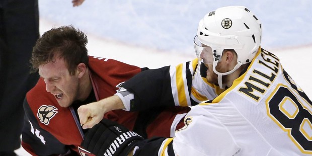 Boston Bruins' Kevan Miller, right, connects with a punch during a fight against Arizona Coyotes' J...