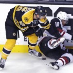 Arizona Coyotes left wing Anthony Duclair (10) hits the ice as Boston Bruins defenseman Joe Morrow (45) tries to dig out the puck during the first period of an NHL hockey game in Boston, Tuesday, Oct. 27, 2015. (AP Photo/Charles Krupa)