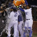 Kansas City Royals catcher Salvador Perez, right, pours a container of water over starting pitcher Johnny Cueto Game 2 of the Major League Baseball World Series against the New York Mets Wednesday, Oct. 28, 2015, in Kansas City, Mo. The Royals defeated the Mets 7-1 to take at two game lead in the series.  (AP Photo/Orlin Wagner)