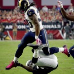 St. Louis Rams running back Todd Gurley (30) jump over Arizona Cardinals cornerback Jerraud Powers during the first half of an NFL football game, Sunday, Oct. 4, 2015, in Glendale, Ariz. (AP Photo/Ross D. Franklin)