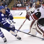 Arizona Coyotes goaltender Mike Smith, right, clears the puck in front of Toronto Maple Leafs' Leo Komarov during second period NHL hockey action in Toronto on Monday, Oct. 26, 2015. (Frank Gunn/The Canadian Press via AP)