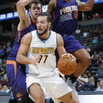 Denver Nuggets forward Joffrey Lauvergne, front, of France, tries to go up for a shot in front of Phoenix Suns forwards Jon Leuer, left, and T.J. Warren during the second half of an NBA basketball game Friday, Oct. 16, 2015, in Denver. The Nuggets won 106-81. (AP Photo/David Zalubowski)