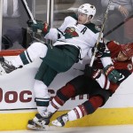 Arizona Coyotes' Steve Downie, right, hits Minnesota Wild's Ryan Suter (20) during the third period of an NHL hockey game Thursday, Oct. 15, 2015, in Glendale, Ariz.  The Wild defeated the Coyotes 4-3. (AP Photo/Ross D. Franklin)