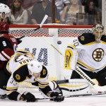 Boston Bruins' Tuukka Rask (40), of Finland, makes a save on a shot as Arizona Coyotes' Tobias Rieder (8), of Germany, is upended by Bruins' Kevan Miller (86) and Zdeno Chara (33), of the Czech Republic, during the first period of an NHL hockey game Saturday, Oct. 17, 2015, in Glendale, Ariz. (AP Photo/Ross D. Franklin)