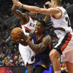 Phoenix Suns guard Eric Bledsoe, center, drives to the basket on Portland Trail Blazers forward Al-Farouq Aminu, left, and forward Mason Plumlee, right, during the first quarter of an NBA basketball game in Portland, Ore., Saturday, Oct. 31, 2015. (AP Photo/Steve Dykes)
