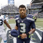 Seattle Seahawks quarterback Russell Wilson (3) leaves the field next to Carolina Panthers' Fozzy Whittaker (43) after an NFL football game, Sunday, Oct. 18, 2015, in Seattle. The Panthers beat the Seahawks 27-23. (AP Photo/Elaine Thompson)