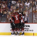 Arizona Coyotes' Connor Murphy (5), Boyd Gordon (15) and Nicklas Grossmann, left, of Sweden, surround Jordan Martinook after his goal against against the Pittsburgh Penguins during the second period of an NHL hockey game Saturday, Oct. 10, 2015, in Glendale, Ariz. (AP Photo/Ross D. Franklin)