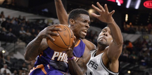 Phoenix Suns guard Eric Bledsoe, left, is defended by San Antonio Spurs forward Tim Duncan during t...