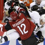 Arizona Coyotes' Brad Richardson (12) checks Pittsburgh Penguins' Evgeni Malkin (71), of Russia, into the boards during the first period of an NHL hockey game Saturday, Oct. 10, 2015, in Glendale, Ariz. (AP Photo/Ross D. Franklin)