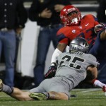 Arizona running back Jared Baker, right, is tripped by Colorado defensive back Ryan Moeller in the first half of an NCAA college football game Saturday, Oct. 17, 2015, in Boulder, Colo. (AP Photo/David Zalubowski)