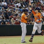 Houston Astros' Colby Rasmus, right, heads for home plate after getting a high-five from third base coach Gary Pettis after his two-run home run against the Arizona Diamondbacks during the sixth inning of a baseball game Friday, Oct. 2, 2015, in Phoenix. (AP Photo/Ross D. Franklin)