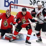 Arizona Coyotes' Brad Richardson (12), Ottawa Senators goaltender Craig Anderson (41) and teammate Mark Borowiecki (74) watch a bouncing puck in front of the Senators net during the first period of an NHL hockey game in Ottawa, Ontario, Saturday, Oct. 24, 2015. (Fred Chartrand /The Canadian Press via AP) MANDATORY CREDIT