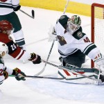 Arizona Coyotes' Michael Stone (26) gets the puck past Minnesota Wild's Devan Dubnyk (40) for a goal as Wild's Nino Niederreiter (22), of Switzerland, arrives late to defend during the third period of an NHL hockey game Thursday, Oct. 15, 2015, in Glendale, Ariz. The Wild defeated the Coyotes 4-3. (AP Photo/Ross D. Franklin)