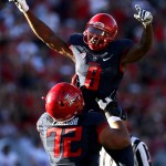 Arizona quarterback Jerrard Randall (8) celebrates with teammate Freddie Tagaloa after throwing a touchdown pass against Washington State during the second half of an NCAA college football game, Saturday, Oct. 24, 2015, in Tucson, Ariz. (AP Photo/Rick Scuteri)