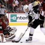 Arizona Coyotes' Nicklas Grossmann (2), of Sweden, shoves Pittsburgh Penguins' Patric Hornqvist, of Sweden, off the puck in front of Coyotes goalie Mike Smith (41) during the second period of an NHL hockey game Saturday, Oct. 10, 2015, in Glendale, Ariz. (AP Photo/Ross D. Franklin)