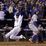 Kansas City Royals' Alcides Escobar scores past New York Mets catcher Travis d'Arnaud during the fifth inning of Game 2 of the Major League Baseball World Series Wednesday, Oct. 28, 2015, in Kansas City, Mo. (AP Photo/David J. Phillip)