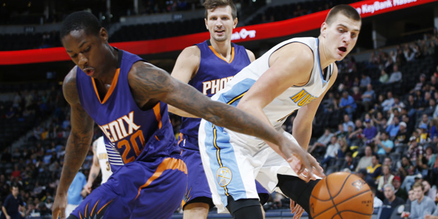 Phoenix Suns guard Archie Goodwin, front, reaches back to steal a pass intended for Denver Nuggets ...