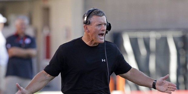 FILE - In this Aug. 28, 2014, file photo, Utah coach Kyle Whittingham shouts as he runs onto the fi...