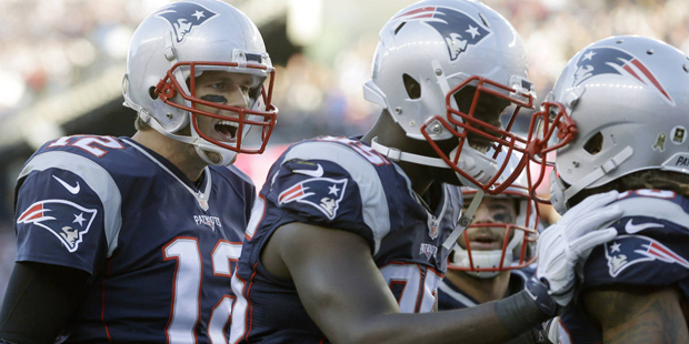 New England Patriots quarterback Tom Brady (12) and defensive end Chandler Jones, center, congratul...