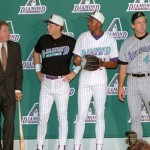 Modeling the uniforms for the new Major League Baseball expansion team, the Arizona Diamondbacks, set to begin play in 1998, are, from left, Danny Manning, Danny Ainge, Wesley Person, coach Paul Westphal, and Kevin Johnson, all of the Phoenix Suns, during a news conference held at America West Arena in Phoenix, Thursday Nov. 2, 1995. In suit, second from left, is Jerry Colangelo, Diamondbacks managing general partner. (AP Photo/Eric Drotter)
