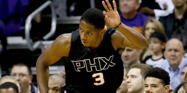 Phoenix Suns' Brandon Knight signals three against the Dallas Mavericks during the first half of an...