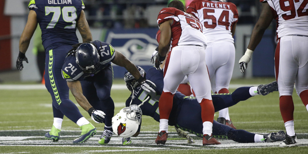 Seattle Seahawks running back Marshawn Lynch (24) and Seahawks' Russell Wilson (3) go down and Ariz...