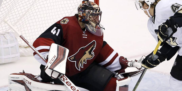 Arizona Coyotes' Mike Smith, left, makes a save on a shot by Pittsburgh Penguins' Daniel Sprong, ri...