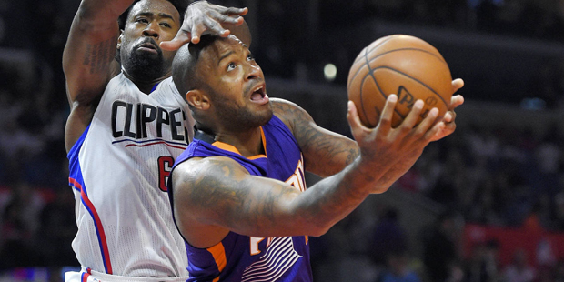 Phoenix Suns forward P.J. Tucker, right, goes up for a shot as Los Angeles Clippers center DeAndre ...