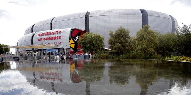 University of Phoenix Stadium is shown reflected in the water prior to an NFL football game between...