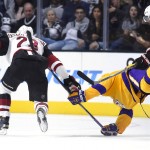 Los Angeles Kings center Anze Kopitar, center, of Slovenia, falls as he tangles with Arizona Coyotes left wing Anthony Duclair, right, as defenseman Oliver Ekman-Larsson, of Sweden, goes after the puck during the second period of an NHL hockey game, Tuesday, Nov. 10, 2015, in Los Angeles. (AP Photo/Mark J. Terrill)
