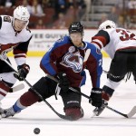 Arizona Coyotes' Max Domi (16) and Tyler Gaudet (32) force the puck away from Colorado Avalanche's Mikhail Grigorenko (25), of Russia, during the first period of an NHL hockey game Thursday, Nov. 5, 2015, in Glendale, Ariz. (AP Photo/Ross D. Franklin)