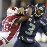 Seattle Seahawks quarterback Russell Wilson (3) is hit by Arizona Cardinals cornerback Justin Bethel just after getting a pass off during the second half of an NFL football game, Sunday, Nov. 15, 2015, in Seattle. (AP Photo/Stephen Brashear)