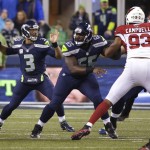 Seattle Seahawks quarterback Russell Wilson (3) passes as center Patrick Lewis (65) blocks Arizona Cardinals' Calais Campbell (93) during the first half of an NFL football game, Sunday, Nov. 15, 2015, in Seattle. (AP Photo/Elaine Thompson)